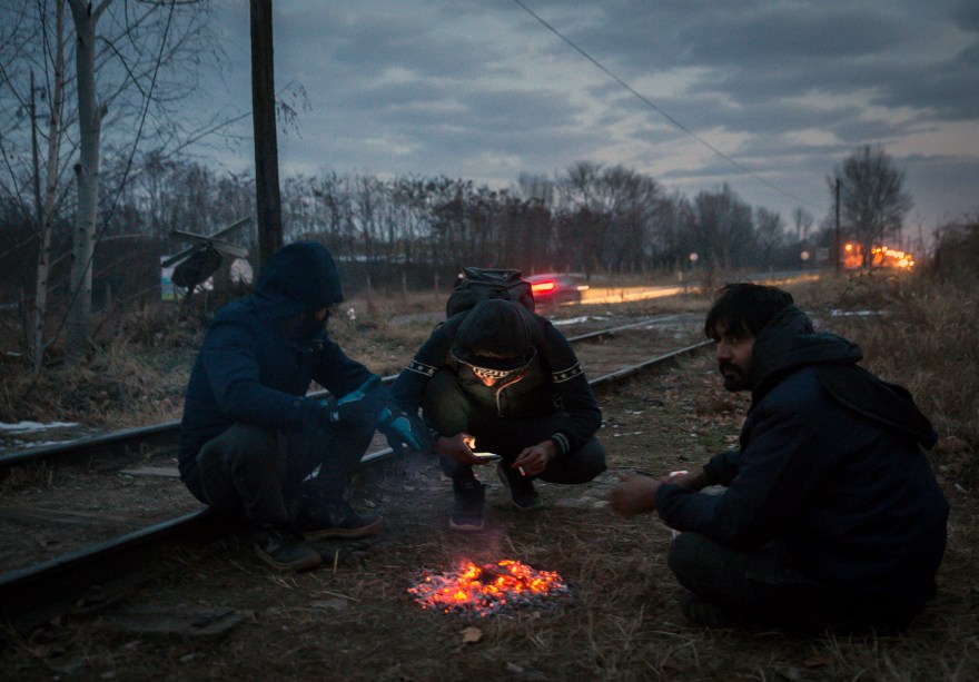 Imigrantes se aquecem em volta de uma fogueira, para se protegerem das temperaturas de menos 20 graus celsius, em Belgrado, Sérvia