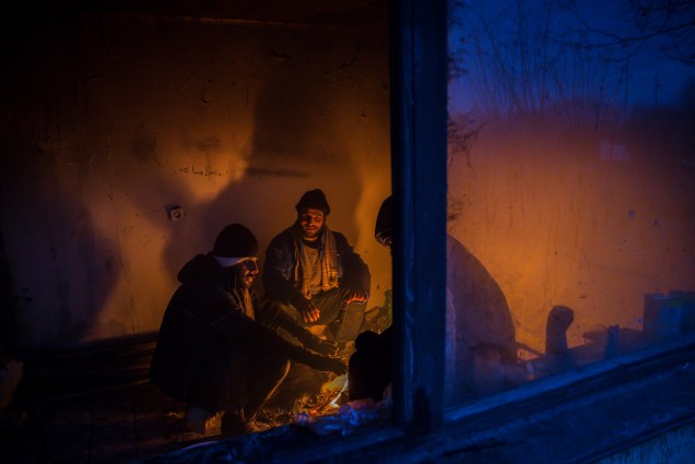 Imigrantes se aquecem em volta de uma fogueira, para se protegerem das temperaturas de menos 20 graus celsius, em Belgrado, Sérvia