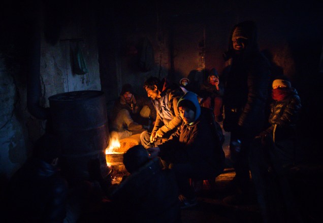 Imigrantes se aquecem em volta de uma fogueira, para se protegerem das temperaturas de menos 20 graus celsius, em Belgrado, Sérvia