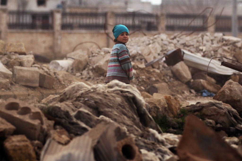 A child walks through rubble of damaged buildings in al-Rai town, northern Aleppo countryside, Syria January 20, 2017. REUTERS/Khalil Ashawi