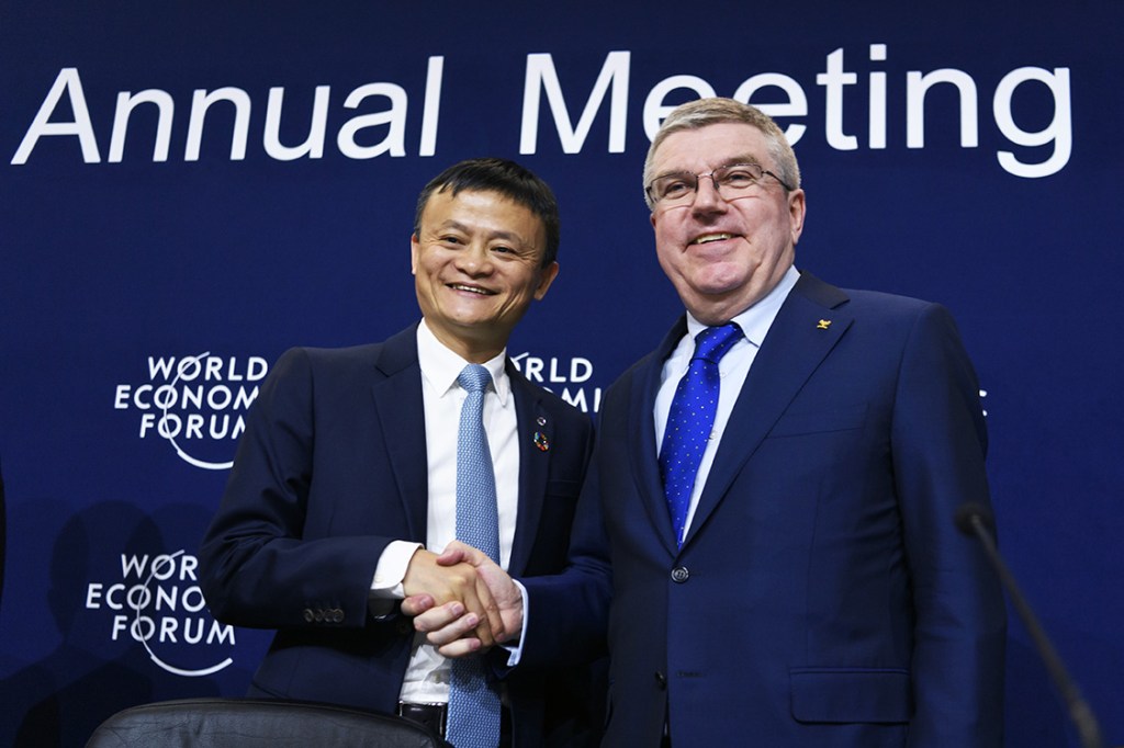 Alibaba Group Founder and Executive Chairman, China's Jack Ma (L) shakes hands with International Olympic Comittee (IOC) president Thomas Bach as they exchange gifts during the anouncement of a long-term partnership of Alibaba as worldwide sponsor on the sideline of the Forum's annual meeting, on January 19, 2017 in Davos. / AFP PHOTO / FABRICE COFFRINI
