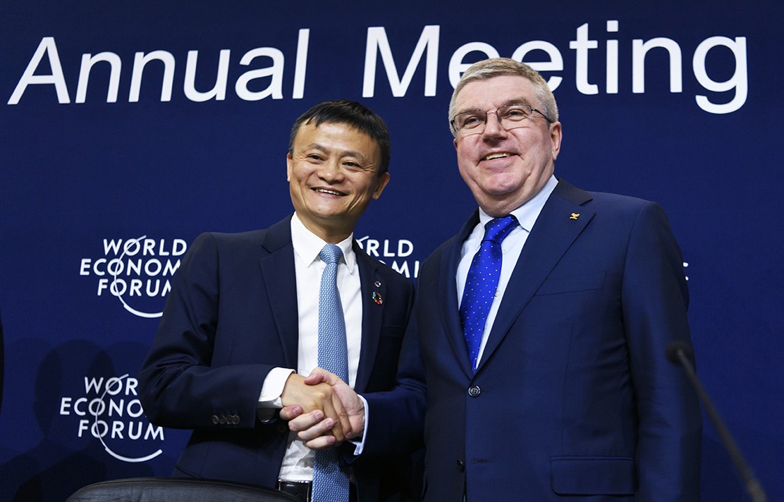Alibaba Group Founder and Executive Chairman, China's Jack Ma (L) shakes hands with International Olympic Comittee (IOC) president Thomas Bach as they exchange gifts during the anouncement of a long-term partnership of Alibaba as worldwide sponsor on the sideline of the Forum's annual meeting, on January 19, 2017 in Davos. / AFP PHOTO / FABRICE COFFRINI