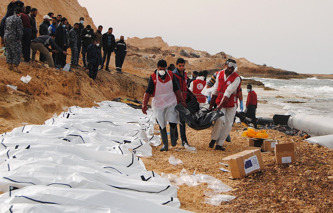 Voluntários trabalham retirando o corpo de 74 refugiados que apareceram na costa de Zawiyah, na Líbia