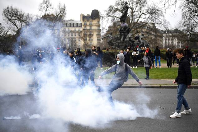 Manifestante chuta lata de gás lacrimogêneo durante protesto contra a violência policial na Place de La Nation, em Paris, França, que ocorreu após o caso "Theo", um estudante que alega ter sido estuprado por policiais - 23/02/2017