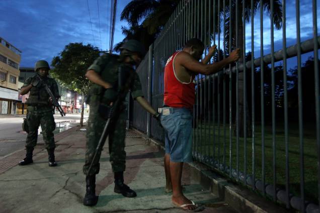 Soldado do Exército revista uma pessoa durante patrulha nas ruas de Vila Velha, no Espírito Santo - 09/02/2017
