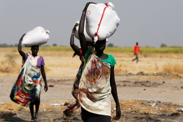 Mulher carrega saco com alimento despejado pelo avião da ONU no vilarejo de Nimini, no Sudão do Sul