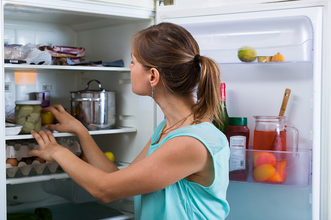 Woman near full fridge