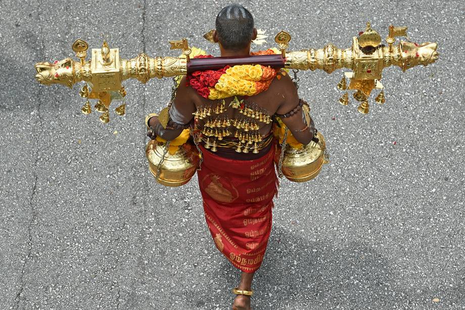 Devoto hindu carrega recipientes contendo leite até o Templo Thendayuthapani em Singapura, durante festival tradicional da lua cheia - 09/02/2017