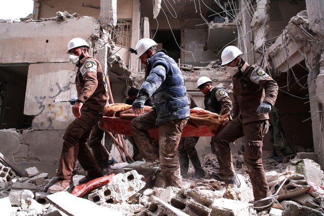 Voluntários da defesa civil da Síria, conhecidos como "Capacetes Brancos", procuram sobreviventes após ataque aéreo do governo na região de Tishrin,dominada por rebeldes, em Damasco - 22/02/2017
