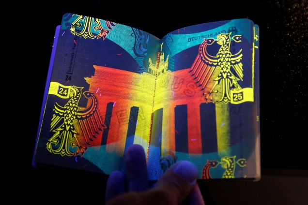 Novo passaporte eletrônico alemão é retratado sob luz ultravioleta durante apresentação aos meios de comunicação em Berlim - 23/02/2017