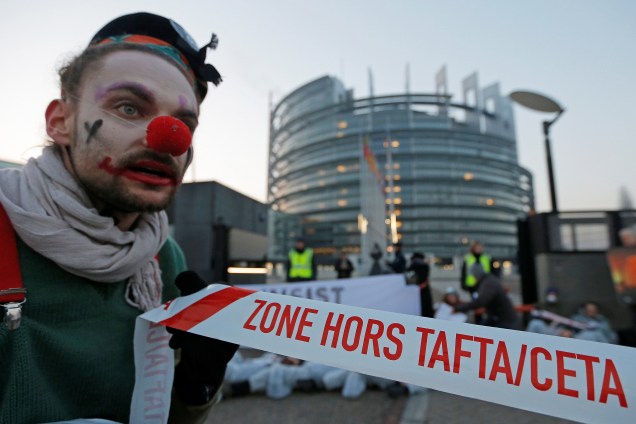 Manifestante vestido de palhaço protesta contra o Tratado de Livre-Comércio e Investimentos entre União Europeia e Canadá (CETA), em Strasbourg, na França - 15/02/2017