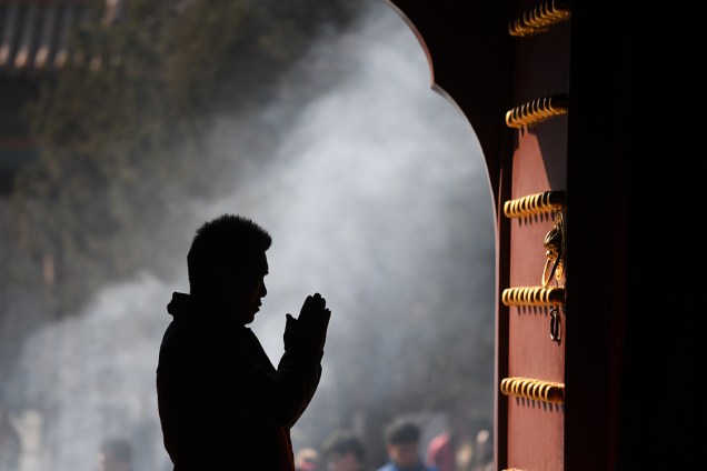 Homem reza no primeiro dia do ano tibetano, no templo de Yonghegong Lama, em Pequim - 27/02/2017