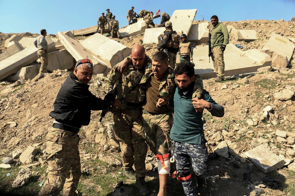 Membros do exército rebelde ajuda civis após ofensiva do Estado Islâmico em Mosul, no Iraque