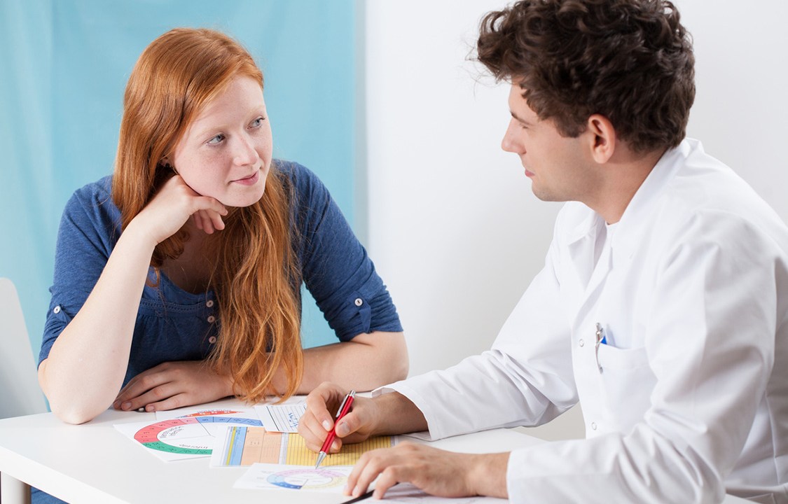 Doctor selecting contraception for young girl, horizontal