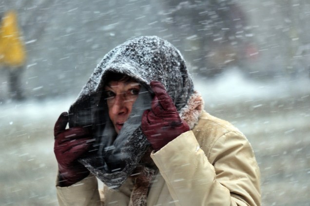 Uma mulher se protege da neve com seu cachecol-09/02/2017