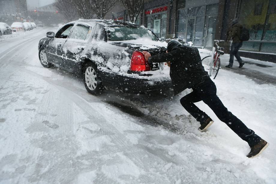 Um homem empurra seu carro durante a nevasca na região do Brooklyn, na cidade de Nova York -09/02/2017