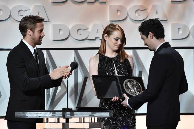 Ator Ryan Gosling e atriz Emma Stone entregam o prêmio de melhor diretor para Damien Chazelle, por sua direção no filme La La Land, em Beverly Hills, Califórnia