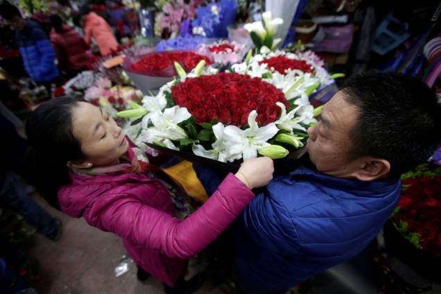 Vendedores empacotam buquês de rosas vermelhas em um mercado de Pequim, na China - 14/02/2017 Vendedores empacotam buquês de rosas vermelhas em um mercado de Pequim, na China - 14/02/2017