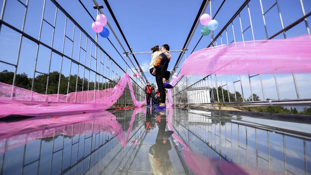 Casal chinês se beija em uma ponte de vidro no centro da província chinesa de Hunan
