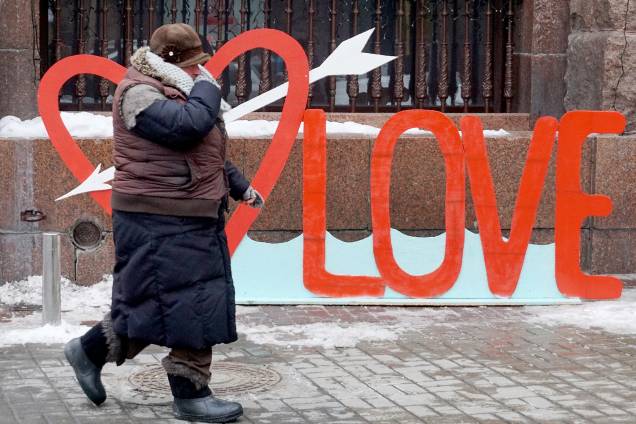 Mulher idosa caminha pelas ruas de Kiev, na Ucrânia, durante comemorações do dia de São Valentim, o Valendtine's Day Mulher idosa caminha pelas ruas de Kiev, na Ucrânia, durante comemorações do dia de São Valentim, o Valendtine's Day