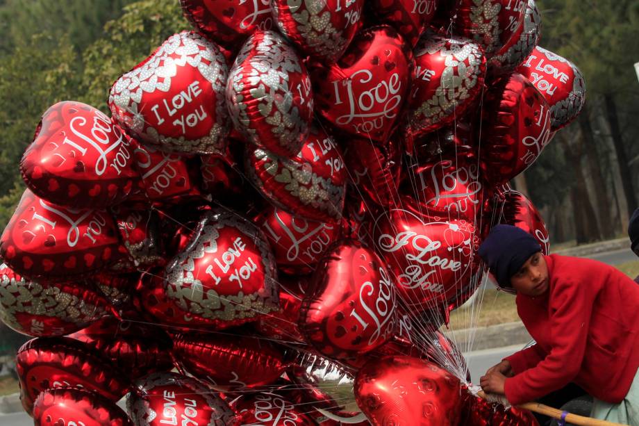 Vendedor caminha com balões em formato de coração no dia de São Valentim