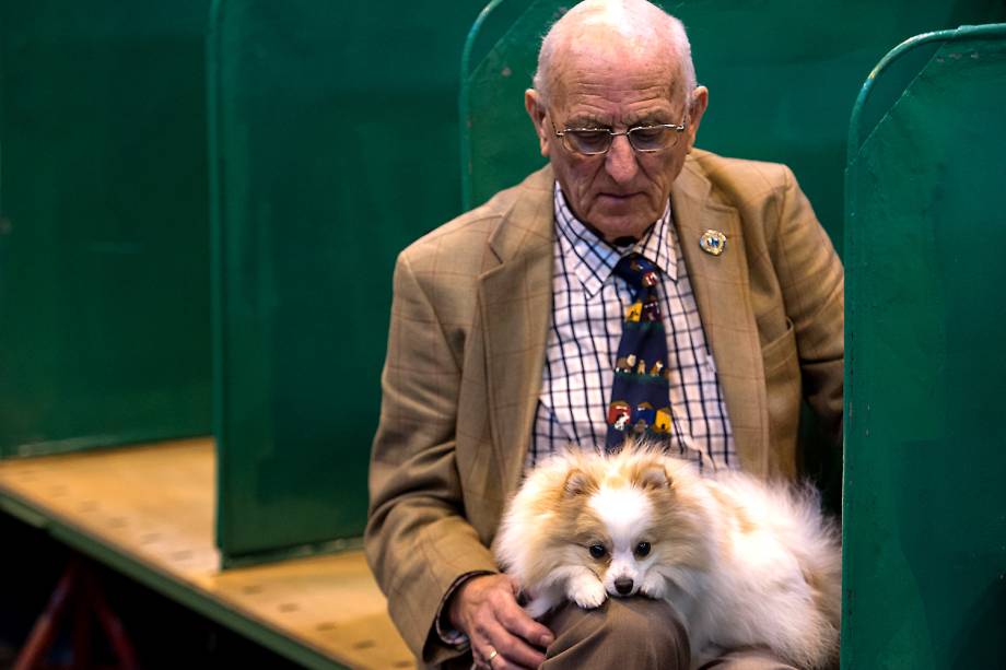 Homem e seu Spitz Alemão no segundo dia do evento Crufts Dog Show em Birmingham, Inglaterra - 10/03/2017