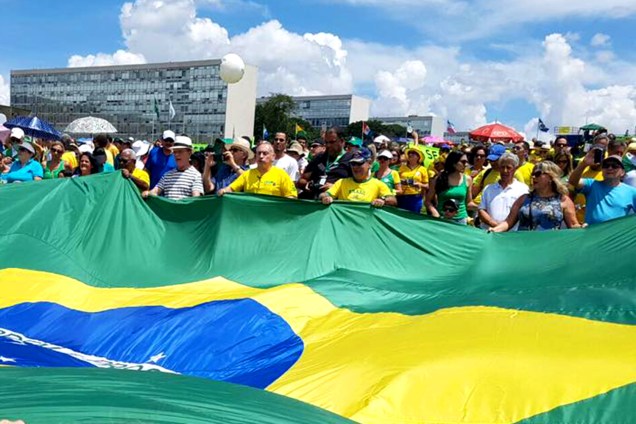 Manifestantes seguram uma bandeira do Brasil durante protesto no Palácio do Planalto em Brasília - 26/03/2017