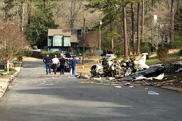 Peritos analisam local onde avião caiu e atingiu casa em Atlanta nos Estados Unidos. O piloto estava sozinho e morreu na queda, enquanto a família que morava na casa atingida estava fora do local no momento do acidente- 25/03/2017