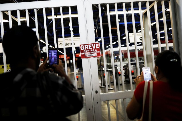 Passageiros tiram foto de portão fechado em estação de metrô de São Paulo durante protesto contra a reforma da Previdência. - 15/03/2017