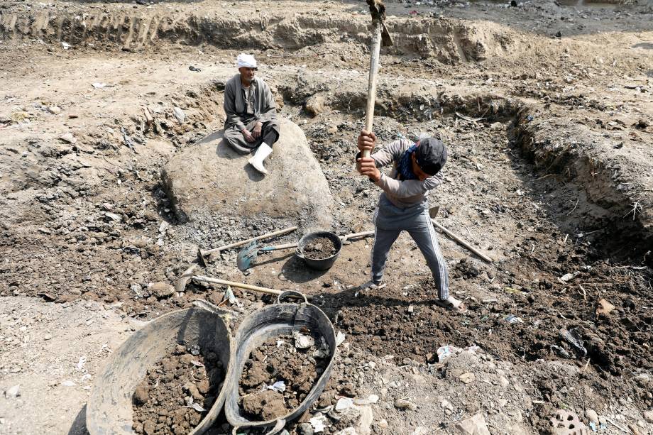 Homens trabalham no local onde uma estátua do faraó Ramsés II foi encontrada em uma favela no Cairo - 09/03/2017