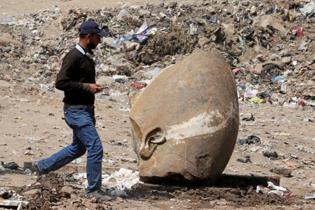Homem passa pelo que parece ser a cabeça de uma estátua do faraó Ramsés II encontrada por trabalhadores em uma favela no Cairo - 09/03/2017
