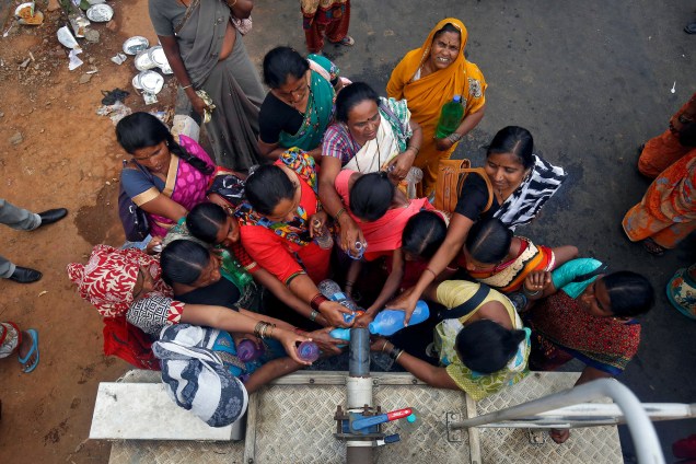 Mulheres enchem recipientes com água de um caminhão-pipa em Bengaluru, na Índia - 21/03/2017