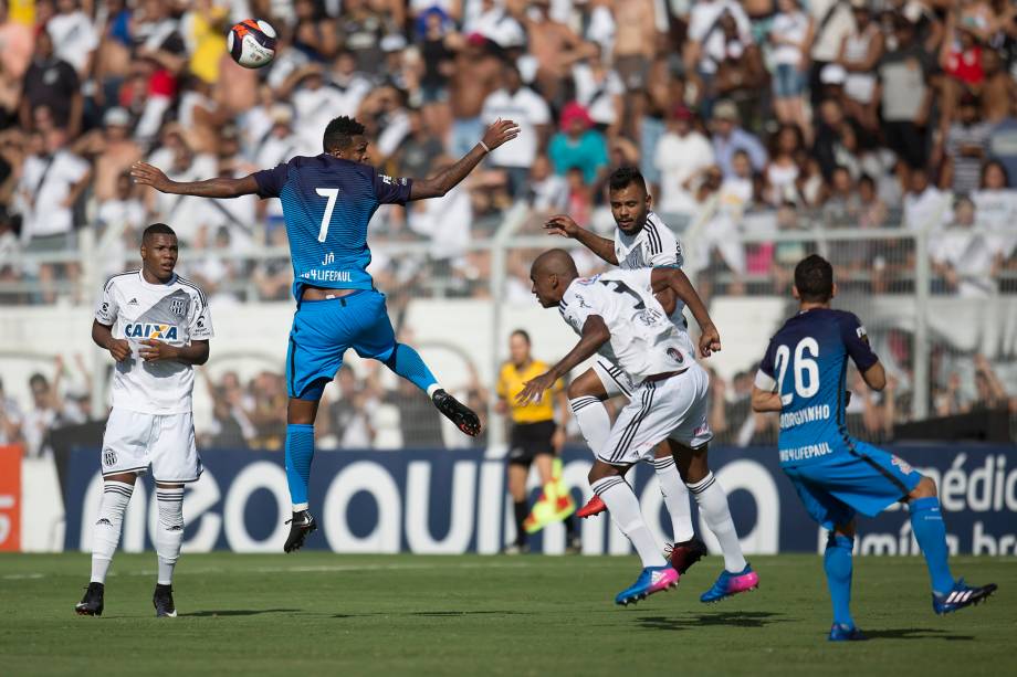 O atacante Jô do Corinthians disputa pelo alto com a defesa da Ponte Preta