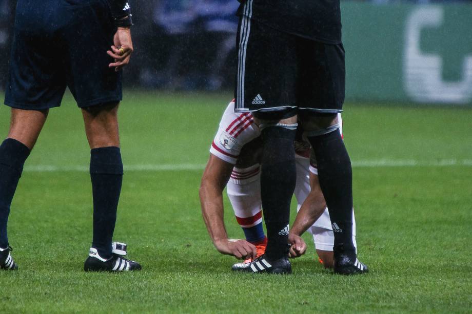 Deu sorte? Zagueiro paraguaio amarra as chuteiras do goleiro Antony Silva antes da cobrança de pênalti desperdiçada por Neymar
