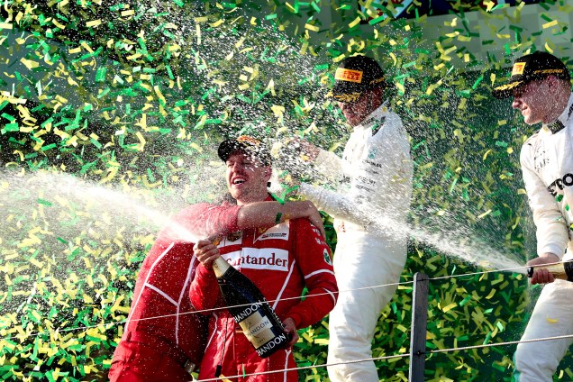Sebastian Vettel da Ferrari (C) celebra sua vitória em 1º lugar no GP da Austrália junto com Lewis Hamilton, que ficou em segundo lugar, e Valtteri Bottas, terceiro colocado na corrida