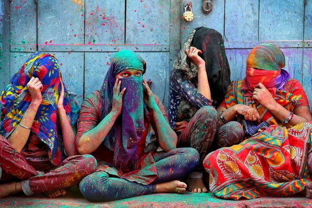 Mulheres em Barsana, Índia, cobrem o rosto durante o festival Holi, que celebra a primavera e tem como tradição uma "guerra" de pó colorido - 06/03/2017