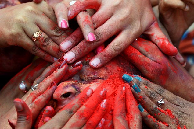 Estudantes passam pó colorido no rosto durante o festival Holi em Calcutá, Índia - 07/03/2017