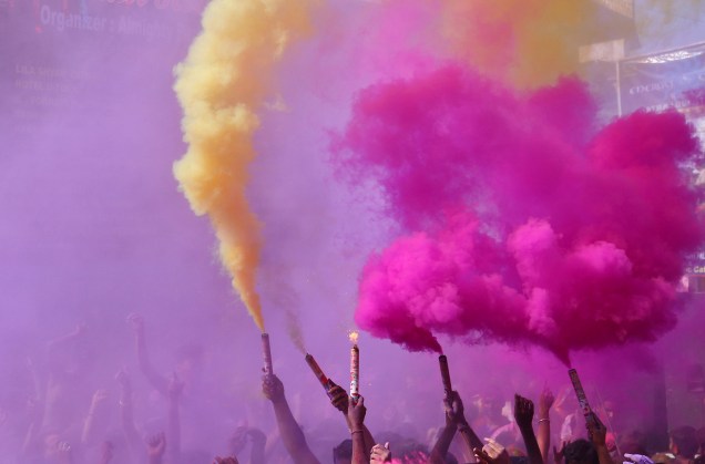 Pessoas celebram o festival das cores, Holi, com fumaça colorida em Rajasthan, Índia - 13/03/2017