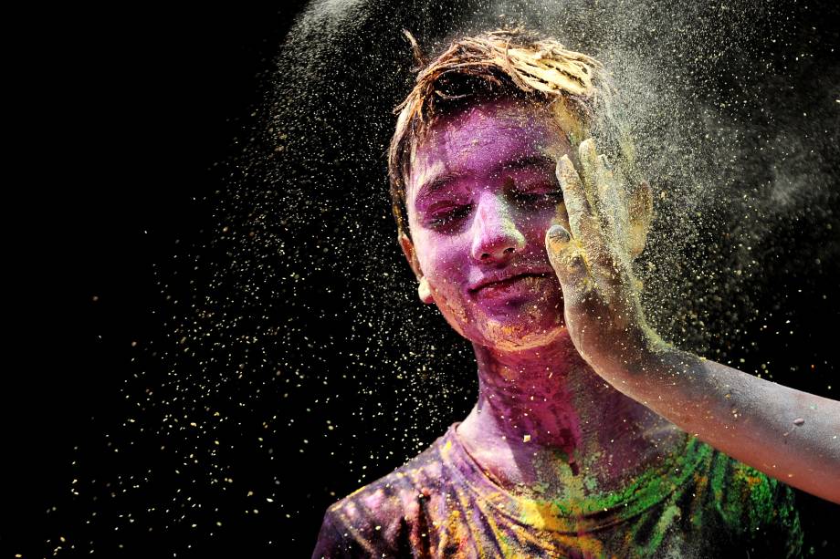 Jovem indiano recebe pó colorido no rosto durante as celebrações do Holi em Chennai - 12/03/2017