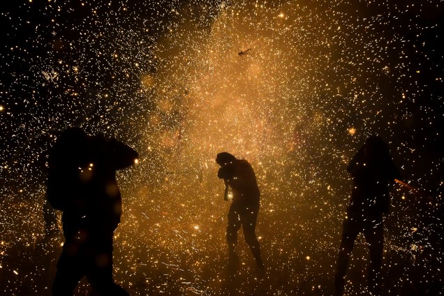 Pessoas protegem o rosto enquanto estouram fogos de artifício no festival do dia de San Juan de Diós, na Cidade do México