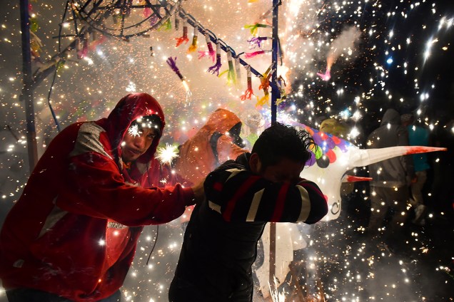 Pessoas protegem o rosto enquanto estouram fogos de artifício no festival do dia de San Juan de Diós, na Cidade do México