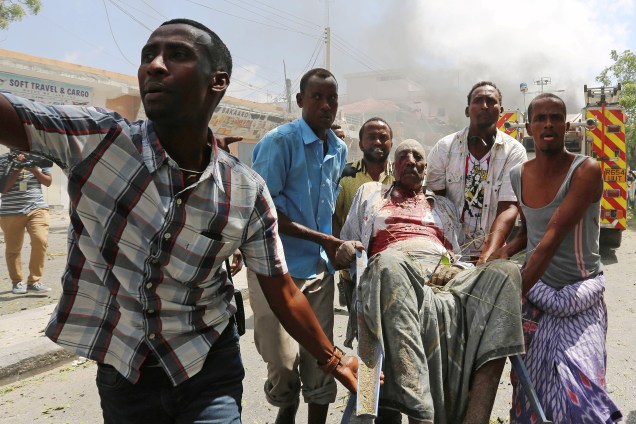 Socorristas levam um homem ferido após uma explosão nos arredores de um hotel em Mogadíscio, capital da Somália - 13/03/2017