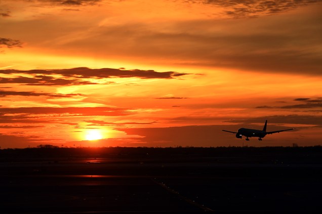 Avião pousa no aeroporto internacional JFK, em Nova York, durante nascer do sol - 24/03/2017