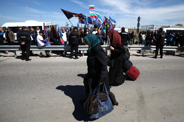 Mulheres carregam bagagem enquanto tentam atravessar a fronteira entre Turquia e Bulgária, durante protesto a favor da abertura da fronteira, fechada por nacionalistas búlgaros para impedir que turcos com passaporte da Bulgária possam votar nas eleições no domingo