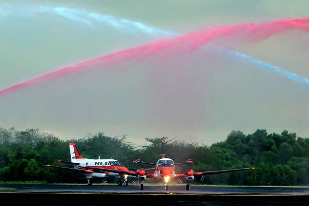 Caminhões de bombeiros jogam jato d'água em duas unidades de aviões de treinamento japoneses, a caminho das Filipinas - 27/03/2017 Caminhões de bombeiros jogam jato d'água em duas unidades de aviões de treinamento japoneses, a caminho das Filipinas - 27/03/2017