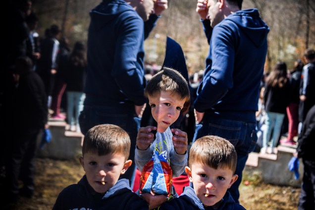 Crianças albanesas são fotografadas em um memorial dedicado às vítimas do massacre da aldeia de Izbica durante a guerra do Kosovo durante cerimônia que marca o 18º aniversário da tragédia - 28/03/2017