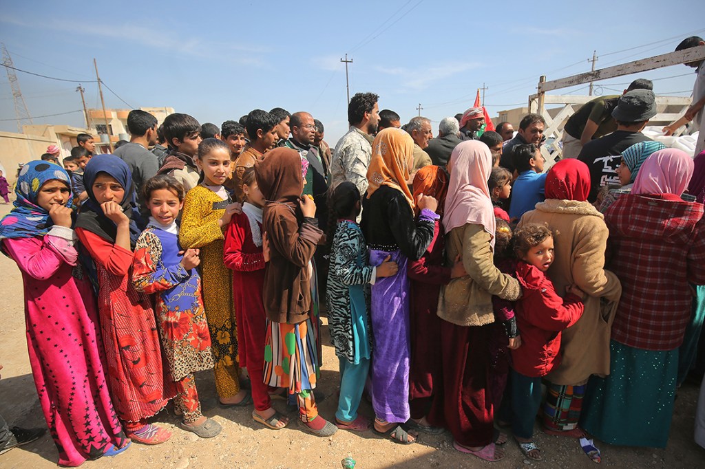 Refugiados aguardam em fila para receberem alimentos após fugirem de Mosul, região em conflito entre o exército de rebeldes e o Estado Islâmico