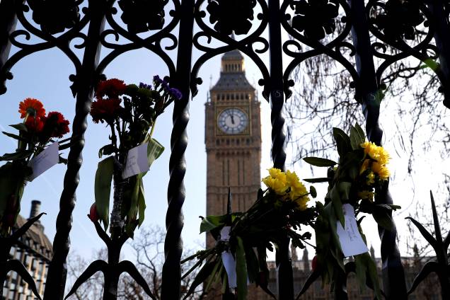 Flores são amarradas nas grades do Parlamento em Londres, Inglaterra, em homenagem às vítimas do atentado na ponte Westminster -27/03/2017
