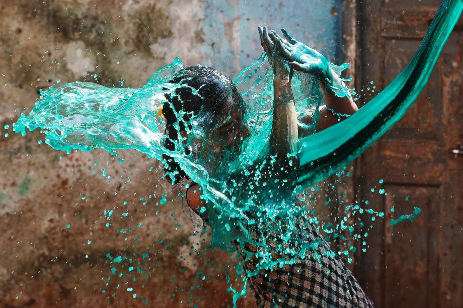Menina recebe um banho de água colorida durante as comemorações do Holi, o festival das cores, em Mumbai, na India - 13/03/2017