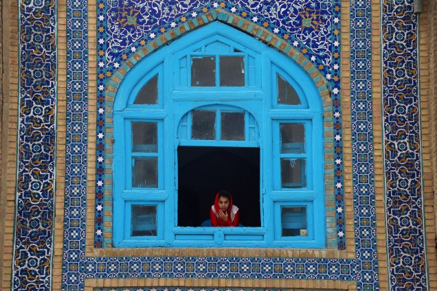 Menina olha de uma janela do santuário de Hazrat-e-Ali durante as festividades do Nowruz que marca o início da primavera e do ano novo persa em Mazari-i-Sharif, no Afeganistão - 21/03/2017